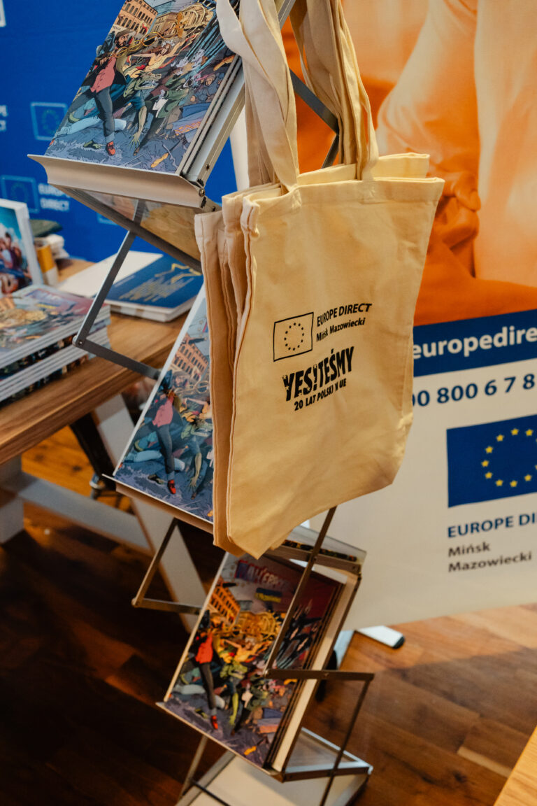 Torby i publikacje na stoisku Europe Direct Mińsk Mazowiecki z napisem „Jesteśmy 20 lat w Unii Europejskiej”.