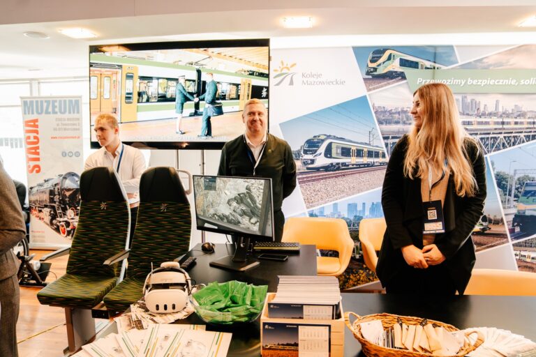 Stoisko Kolei Mazowieckich podczas Forum Rozwoju Mazowsza — prezentacja foteli kolejowych, symulatora VR i materiałów promocyjnych