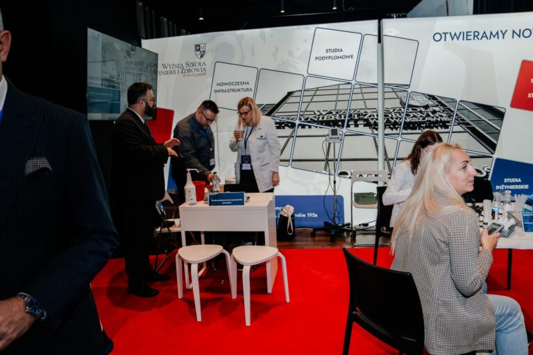 Stoisko Wyższej Szkoły Inżynierii i Zdrowia w Warszawie podczas 15. Forum Rozwoju Mazowsza, gdzie przedstawiciele uczelni prezentują ofertę edukacyjną i nowoczesną infrastrukturę uczelni.