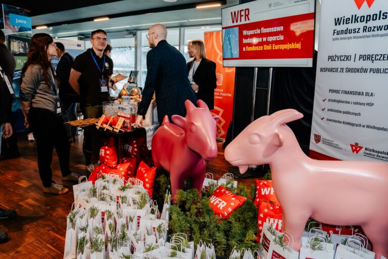 Stoisko Województwa Wielkopolskiego podczas 15. Forum Rozwoju Mazowsza, z charakterystycznymi różowymi koziołkami i materiałami promocyjnymi Wielkopolskiego Funduszu Rozwoju.