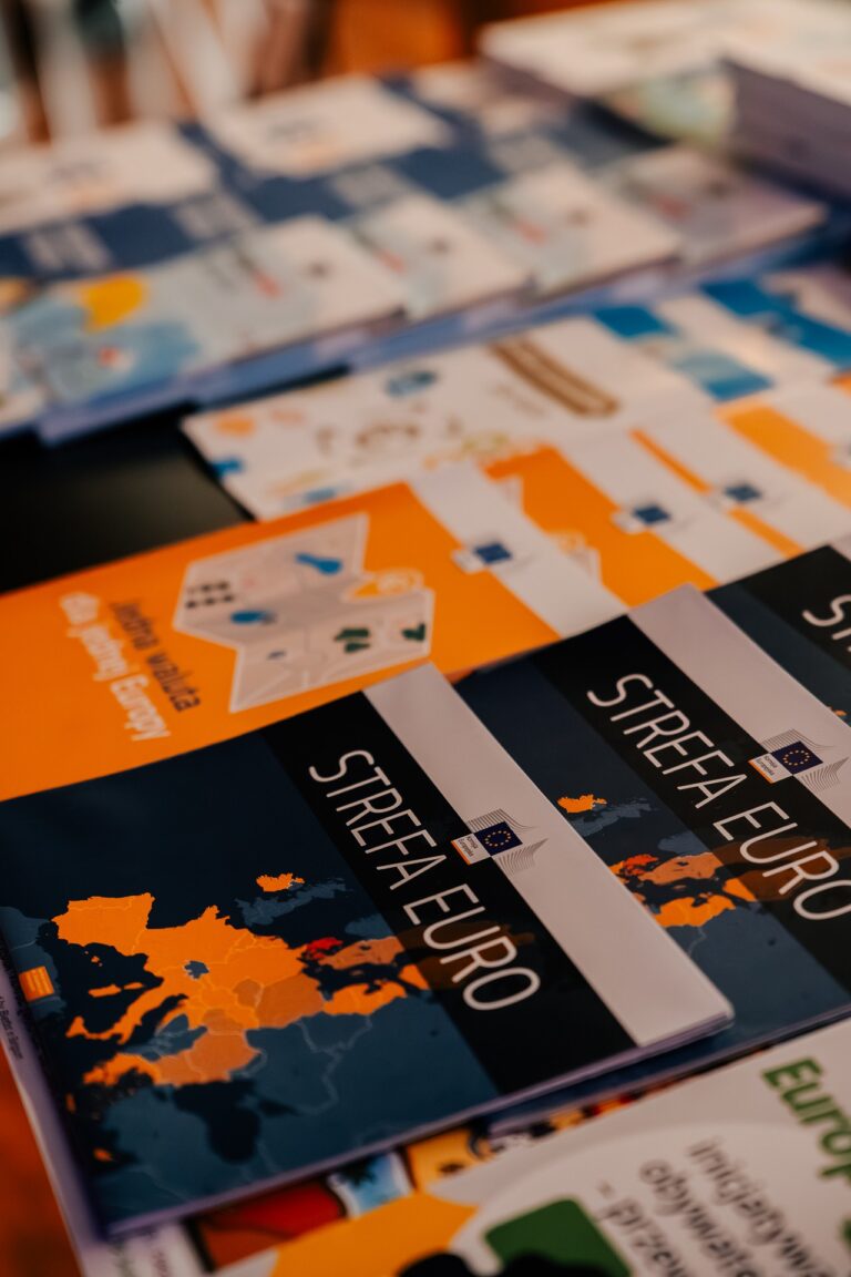 Stos ulotek i broszur informacyjnych Unii Europejskiej, w tym publikacje zatytułowane „Strefa euro” z mapą Europy na okładce.