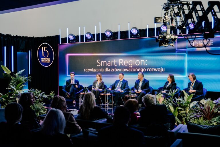 Debata Smart Region: rozwiązania dla zrównoważonego rozwoju. Na Scenie moderator Jakub Tołkaczewski oraz uczestnicy Weronika Wesołowska, Rafał Rosiński, Adam Piotrowski, prof. Hanna Godlewska - Majkowska oraz Wojewoda Mazowiecki Mariusz Frankowski