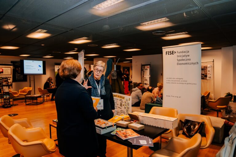 Strefa Fundacji Inicjatyw Społeczno-Ekonomicznych (FISE) podczas 15. Forum Rozwoju Mazowsza – uczestniczki rozmawiają przy stanowisku promującym działania fundacji na rzecz równego dostępu do pracy i rozwoju społecznego.