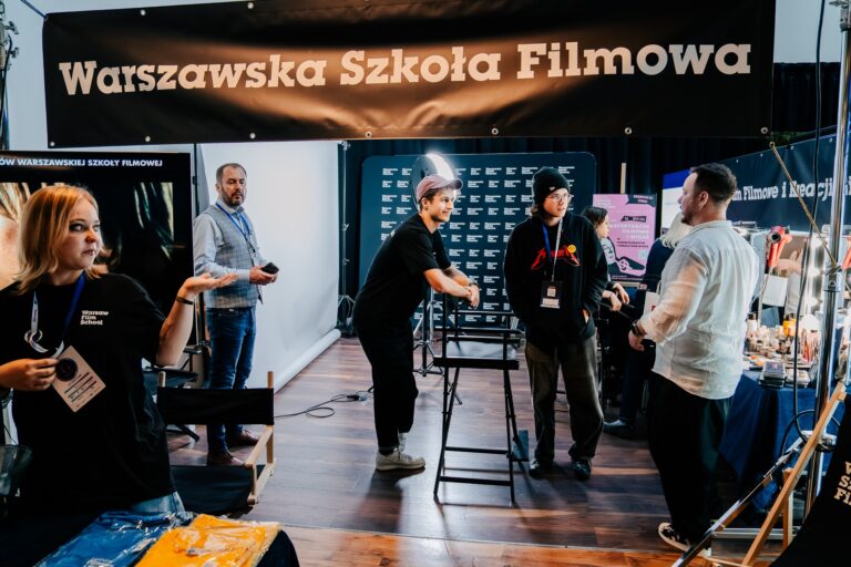 Przedstawiciele Warszawskiej Szkoły Filmowej rozmawiają z uczestnikami wydarzenia przy stoisku podczas 15. Forum Rozwoju Mazowsza.