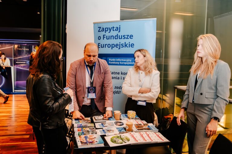 Przedstawiciele Punktu Informacyjnego Funduszy Europejskich rozmawiają z uczestnikami przy stoisku podczas 15. Forum Rozwoju Mazowsza.